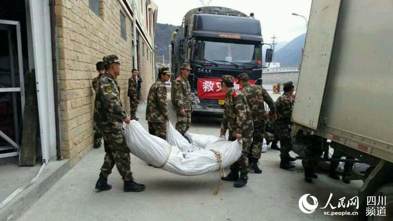 武警官兵正在搬運救災物質。