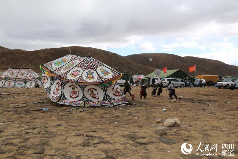 11月23日下午，氣溫突降，冷風驟起。學生們在奮力扶正被吹歪了的帳篷。記者王明峰攝於震中塔公鄉