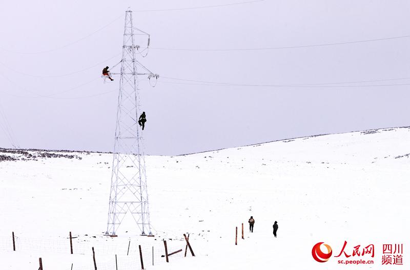 在海拔4800米的高原，温度零下20摄氏度。电力施工人员在恶劣的自然环境下登塔施工作业。（田海 摄）