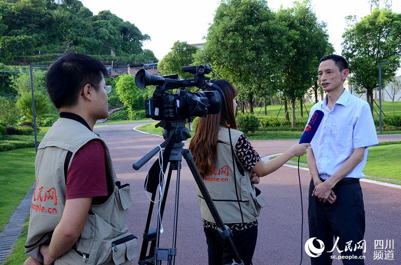 自贡市园林局局长李泽明向人民网记者介绍釜溪河复合绿道相关情况。（刘浏 摄）