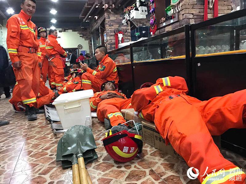 持續救援了一天的消防官兵累倒在地，無暇顧及身躺何處。李平 攝