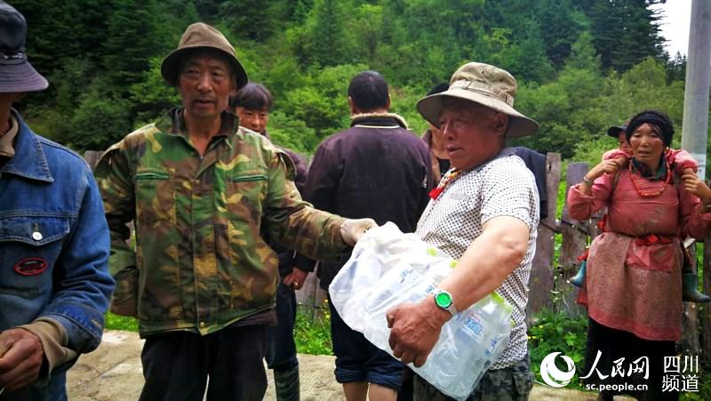 澤旺扎西老人搬運泥土包。（汪子娟 攝）