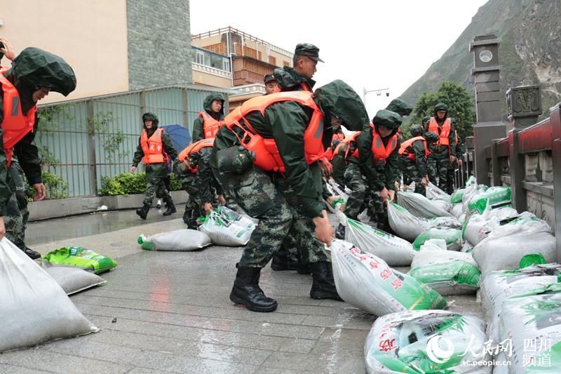 武警阿壩支隊汶川中隊官兵正在搬運沙袋。（馬治宇 攝）