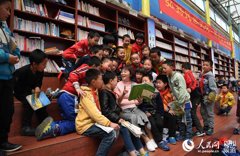 李修會和孩子們一起看書分享快樂。劉傳福 攝