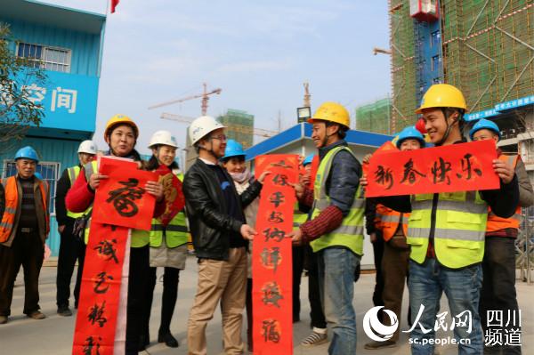 工地工人接過春聯喜迎新年。李安心攝