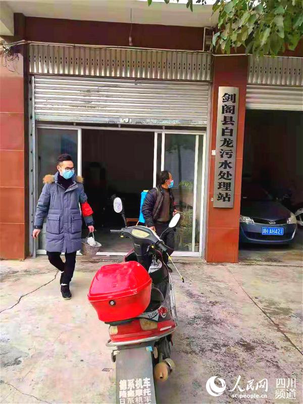 劉洪志（左）幫助群眾進行消毒工作。梁杰 攝