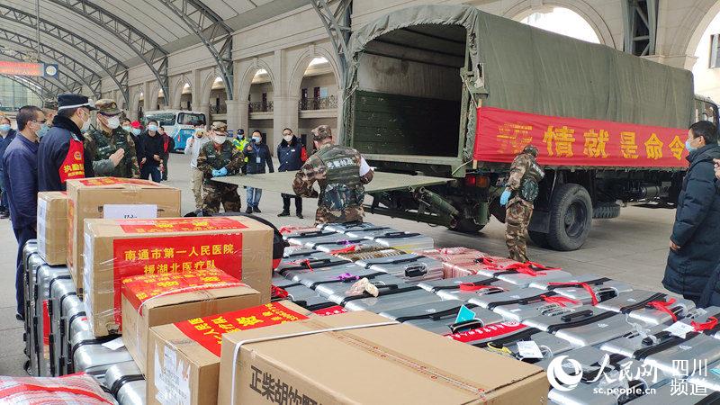 圖為2月24日，D636次列車抵達漢口站，站車工作人員協助醫療隊搬運醫療物資和行李（白曉亮 攝）