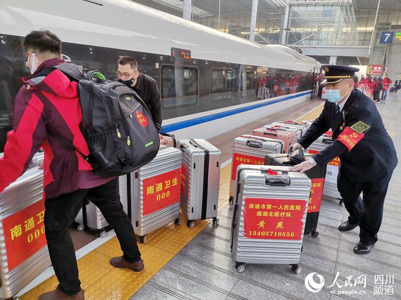 圖為2月24日，D636次列車工作人員在無錫站上協助醫護人員搬運行李。（白曉亮 攝）