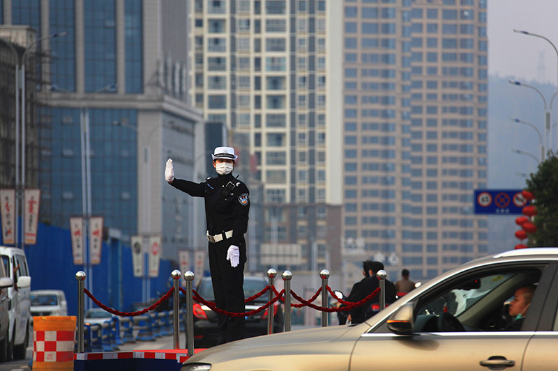2020年2月25日，巴中市回風交通崗亭女交警正在指揮交通解禁后車輛通行。（張學金 攝）