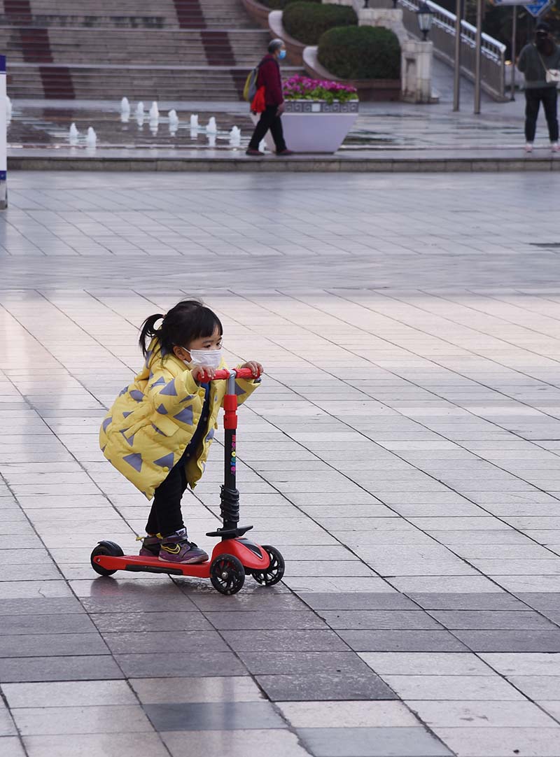 2020年2月29日，綿陽市鐵牛廣場。一名小女孩正在玩滑車。（許榮生 攝） 