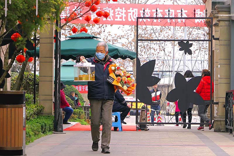 2020年2月23日，成都都江堰市，天府大道紫荊城小區，一位手持生日蛋糕和鮮花的“老爺子”。（吳孝賢 攝）