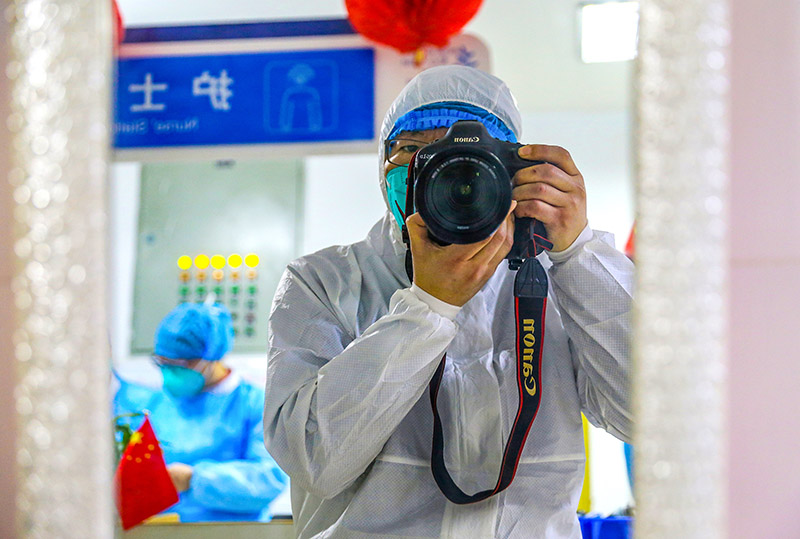 2020年1月24日（大年三十），四川省綿陽市。媒體首次進入綿陽市傳染病醫院隔離區，綿陽日報社記者面對鏡子，拍下穿著隔離服的工作照。（蒲滔 攝）