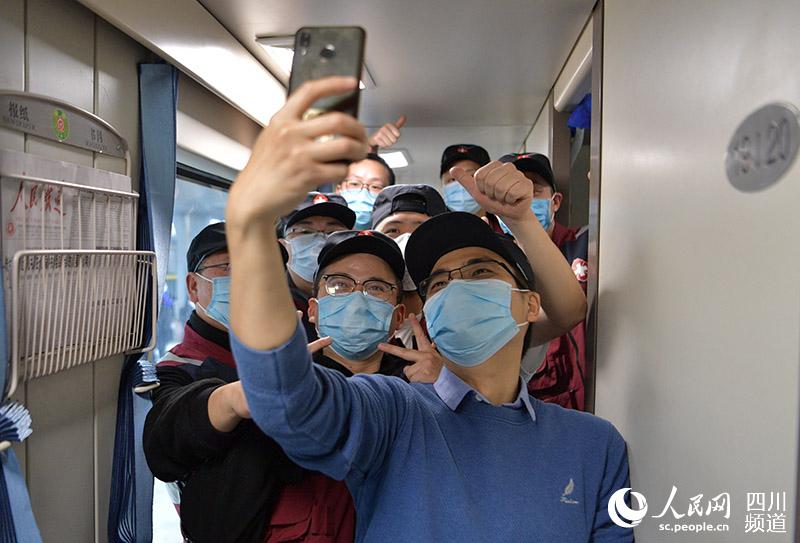 2020年2月4日，四川省人民醫院等9家醫療衛生機構72名隊員組成的國家(四川)緊急醫學救援隊從成都出發，隊員們在列車上自拍。 （劉忠俊 攝）