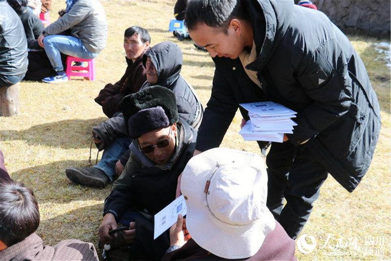 扎西本為村民發放宣傳資料。汪子娟 攝