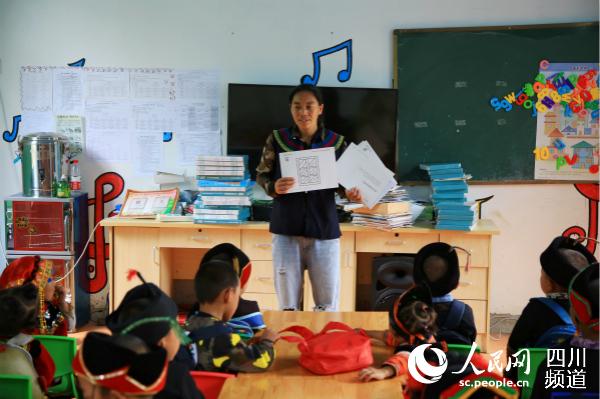美姑縣巴古鄉勒布村幼教點老師正在教孩子們識字。人民網 朱虹 攝