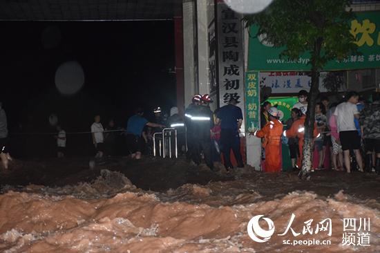 消防指戰員正在湍急的水中轉移被困師生。四川省消防救援總隊供圖