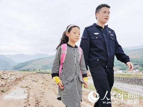 民警张弢陪同木出子里上学。内江公安供图