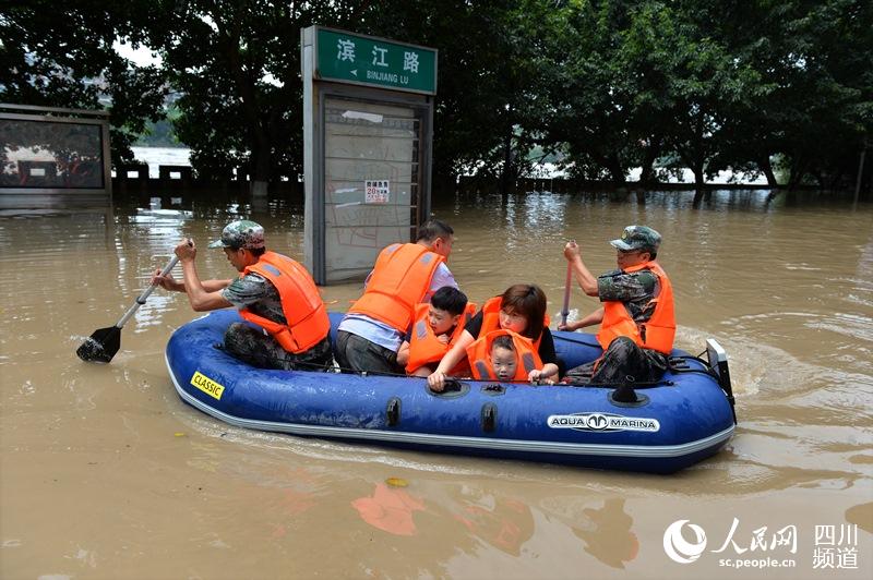8月17日12時15分，資中縣應急民兵在資中縣濱江路用皮劃艇轉移被洪水圍困的群眾 。王斌 攝