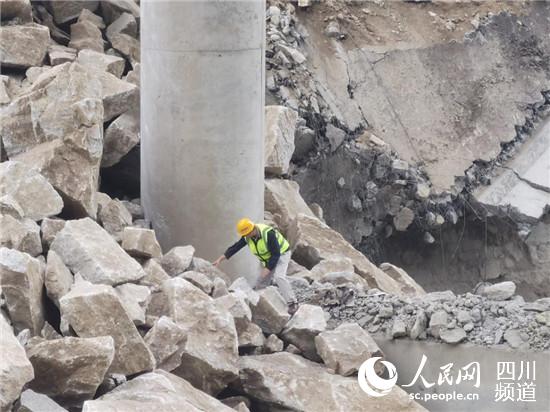 亂石林立、水流湍急，四川公路設計院工作人員不懼危險抵進觀察橋墩受損情況。四川公路設計院供圖