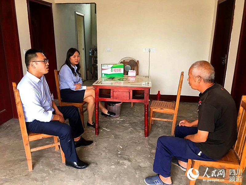 刁哲(左一)在貧困戶家中走訪。四川天府銀行供圖