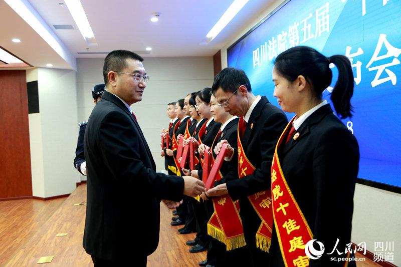 熊焱（左）為“十佳庭審”單位的代表頒發榮譽証書。劉瀏 攝