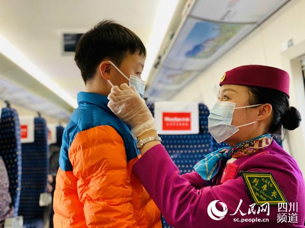 G3286次列車列車長提醒小乘客佩戴好口罩。中國鐵路成都局集團有限公司供圖