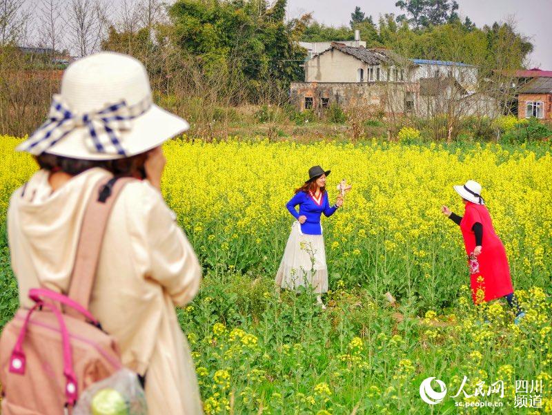 游客們穿行於美麗的油菜花海。人民網 記者彭博攝