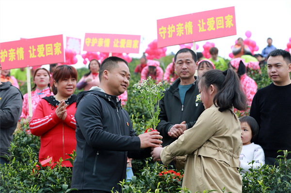 廖悅辰給大竹縣白茶種植帶頭人廖紅軍（左）獻花 。大竹縣宣傳部供圖