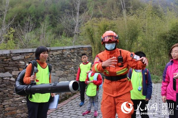 4月3日，四川卧龙中华大熊猫苑神树坪基地内，森林消防员与师生亲密互动。吴鹏飞摄