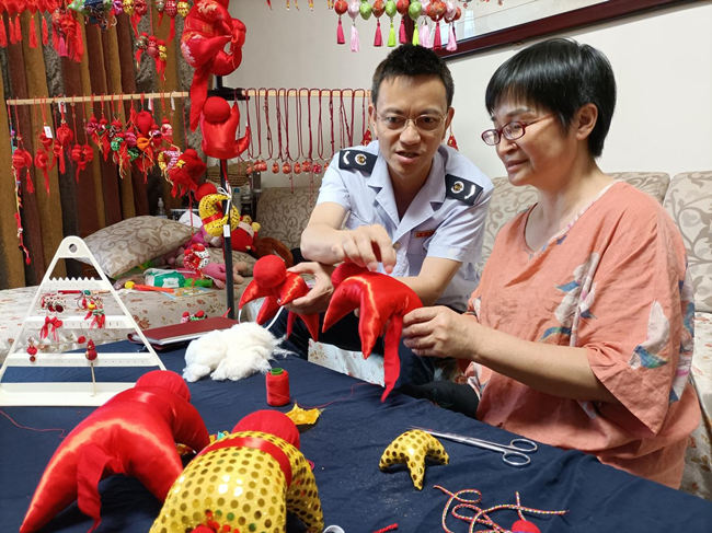 楊麗平為稅務人員講解“香猴猻”的制作方法。四川省稅務局供圖