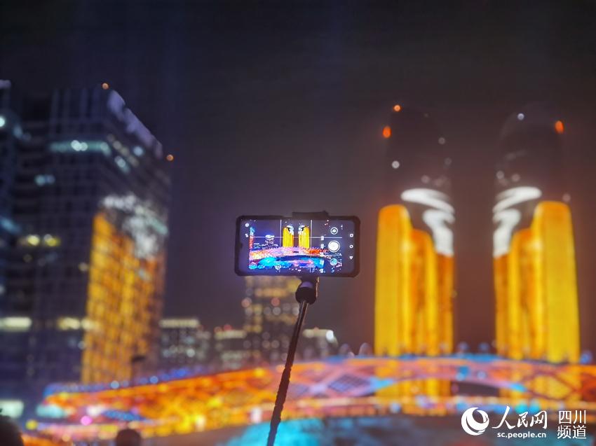 市民用手機拍攝天府雙塔的燈光秀。人民網 王洪江攝