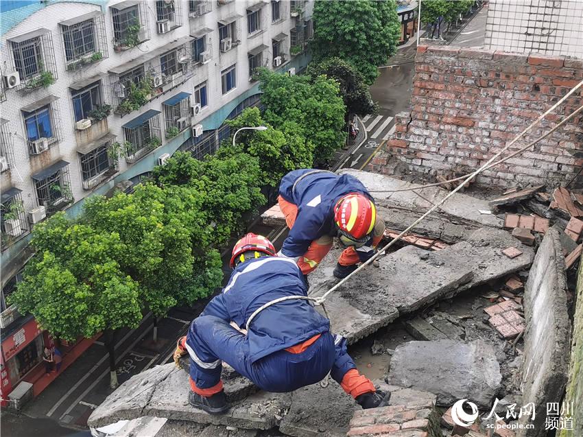 救援人員在瀘縣萬福商業廣場屋頂邊緣清理危險倒塌物。宋良彬攝