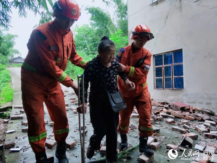 藏族消防員阿君和隊友楊小福在震中萬寶村轉移腿腳不便的群眾。代苗苗攝