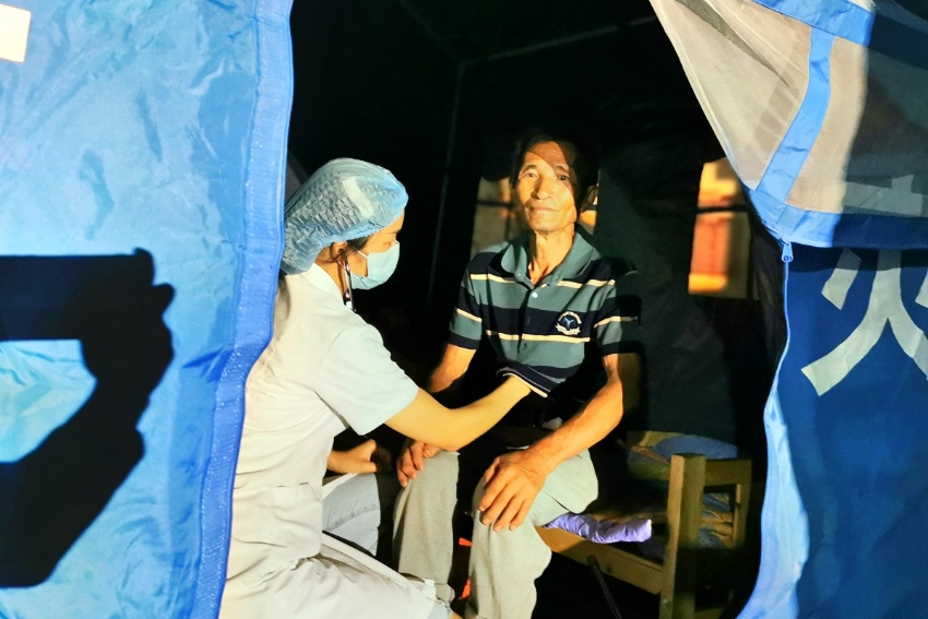 嘉明醫務人員在嘉明小學安置點為一名群眾進行心臟檢查。瀘縣融媒體中心供圖