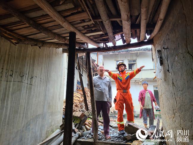 成都消防指战员为受灾居民房进行建筑结构评估。杨长俊摄