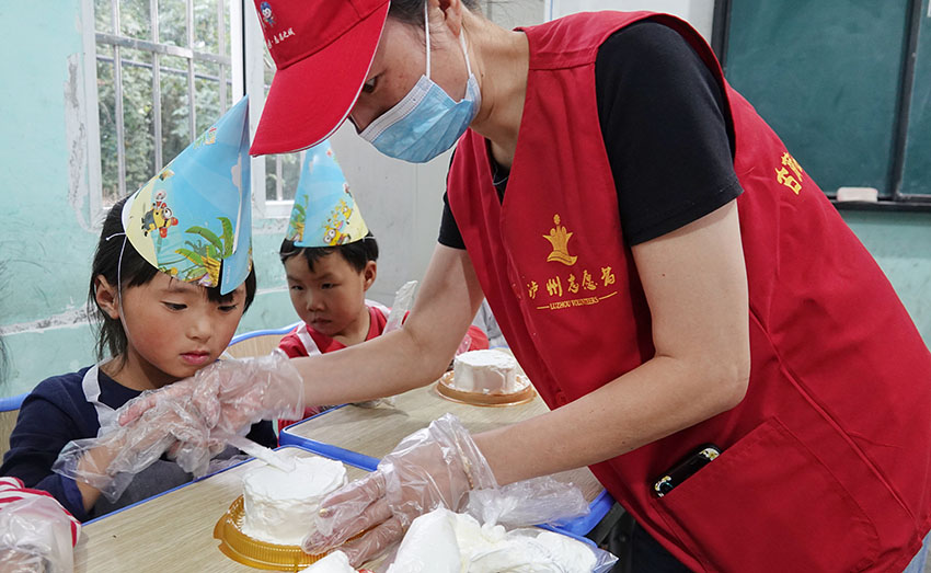 志願者細心指導孩子們制作蛋糕。古藺縣融媒體中心供圖