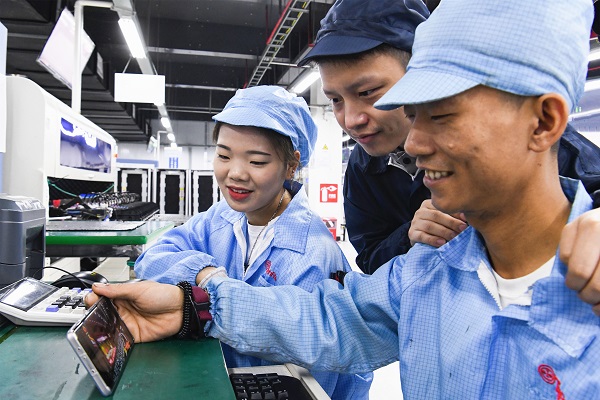 10月13日上午，天寶錦湖公司生產線上，工人用手機收看中國共產黨達州市第五次代表大會現場直播。大竹縣委宣傳部供圖