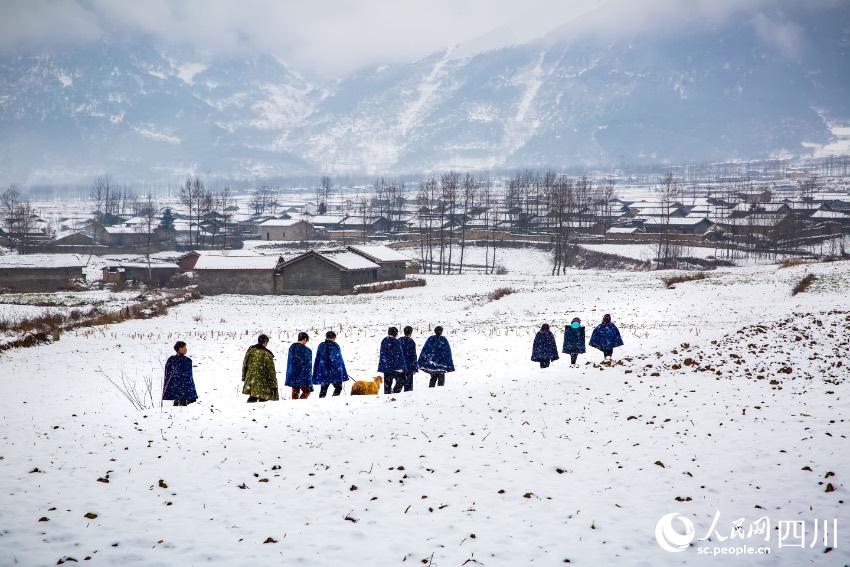 深冬涼山州布拖縣木耳鄉的村民從雪地中走過。楊黎明攝