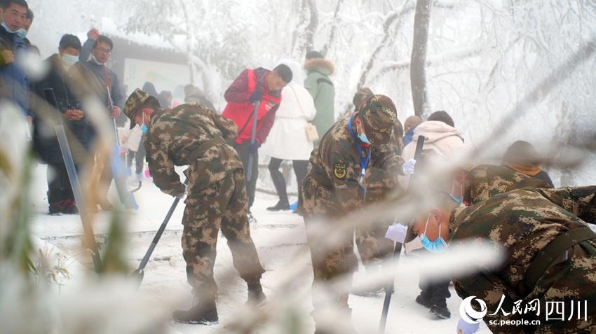 武警樂山支隊官兵在峨眉山協助景區工作人員鏟除路上積雪。何偉俊攝