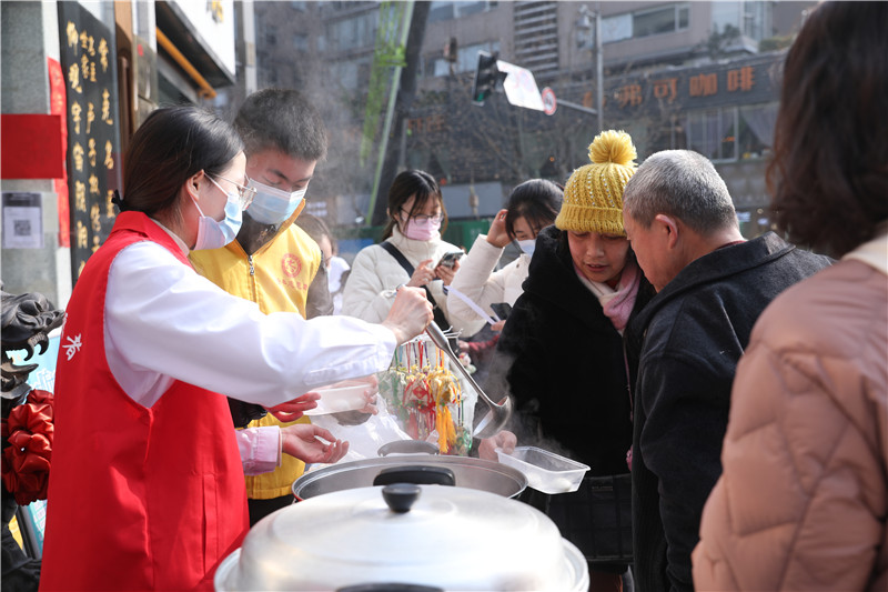 大运会志愿者将热气腾腾的汤圆分发给在场的居民。大运会执委会供图