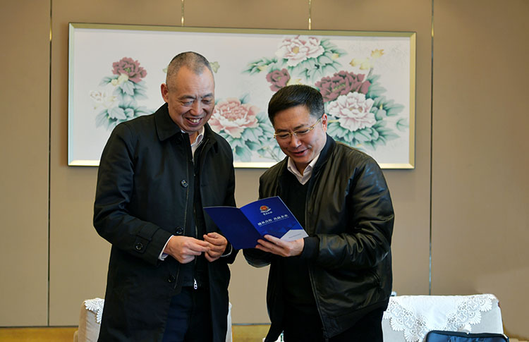李杰(右）向张建明介绍减税降费政策。四川省税务局供图