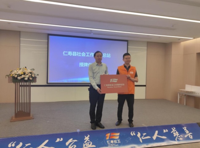 仁壽縣民政局局長王大章向仁壽縣社會工作服務總站副站長周凌旭授牌。仁壽縣民政局供圖