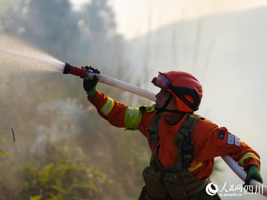 4月21日，成都市森林消防大队一中队消防员陈龙子在赵家镇林区使用水泵进行灭火。程雪力摄