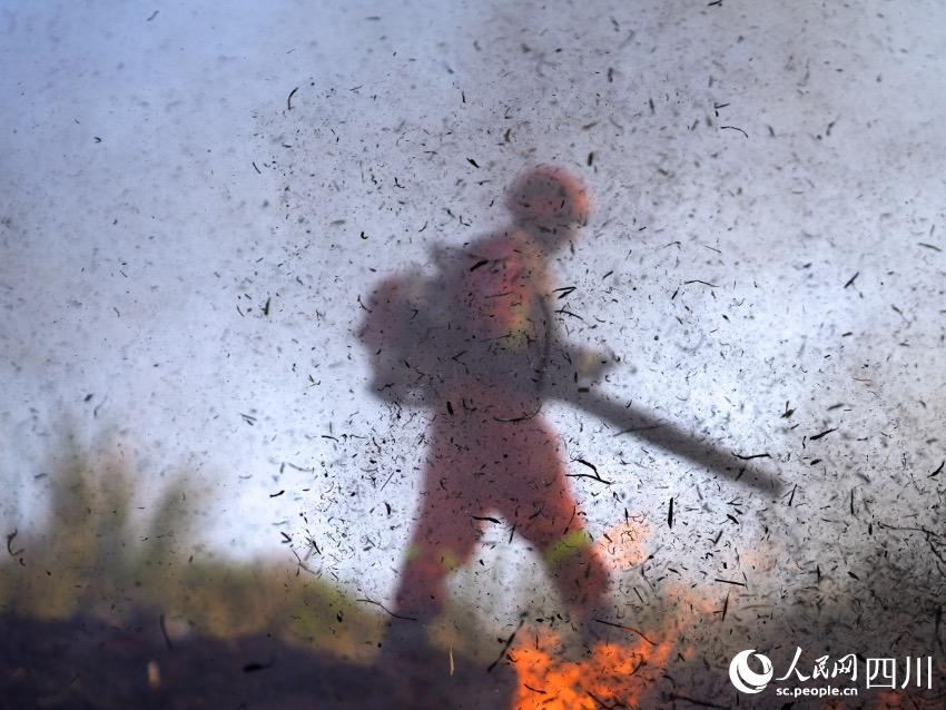 4月21日，四川省成都市金堂县赵家镇林区，成都市森林消防大队一中队一名消防员正在使用常规机具扑打火线。程雪力摄