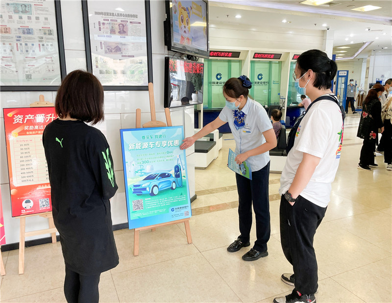 建行網點員工為客戶介紹新能源購車分期活動。建行四川省分行供圖