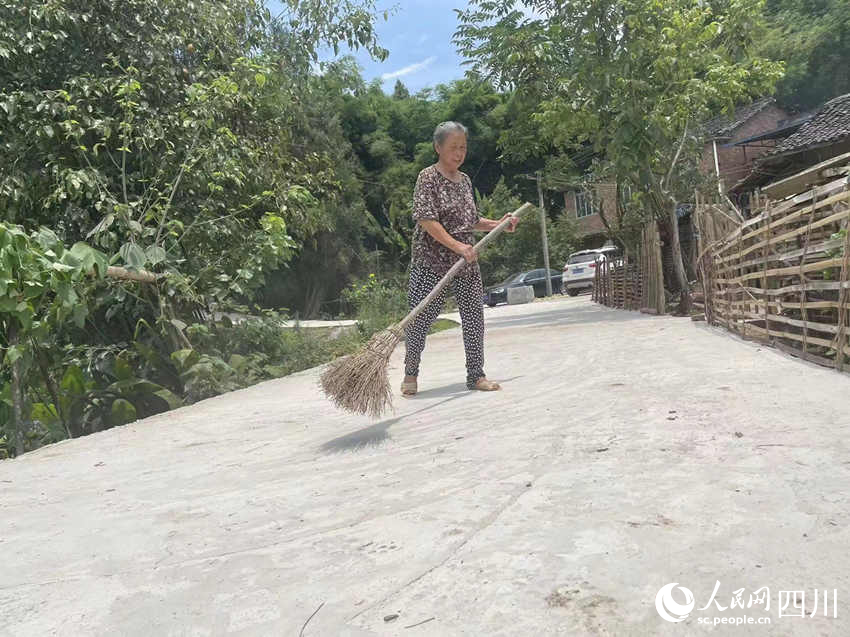 村民杨莲珍正在打扫马路。人民网记者 李平摄