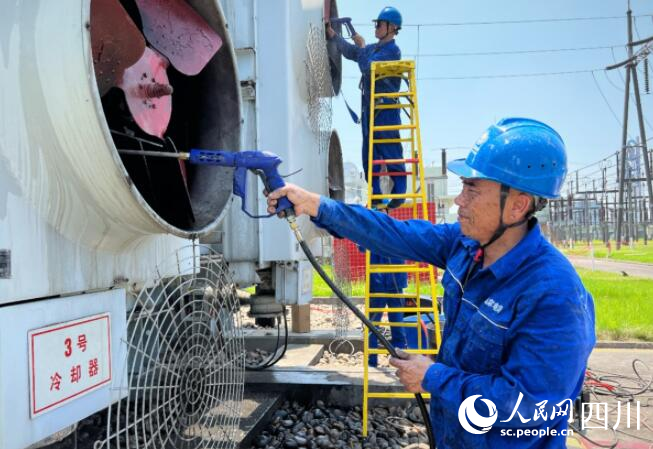 7月6日,在四川省眉山市彭山区220千伏先锋变电站,电力工人正对设备进行降温,确保迎峰度夏设备安全稳定运行。牟雯雯摄