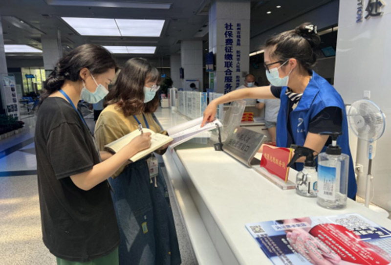 检查政务大厅群众意见簿回访情况。彭州市行政审批局供图