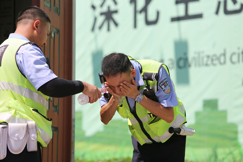 烈日下交警用水降暑。绵阳市公安局供图