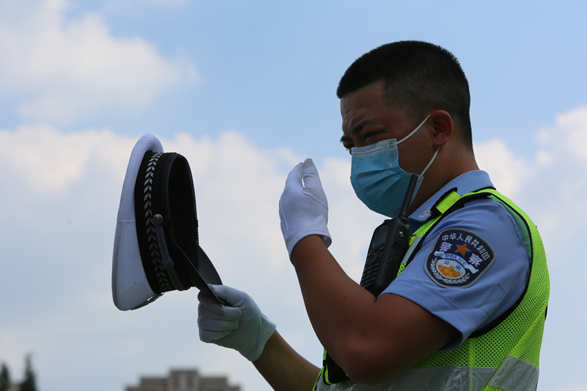 交警摘下帽子搽汗。绵阳市公安局供图
